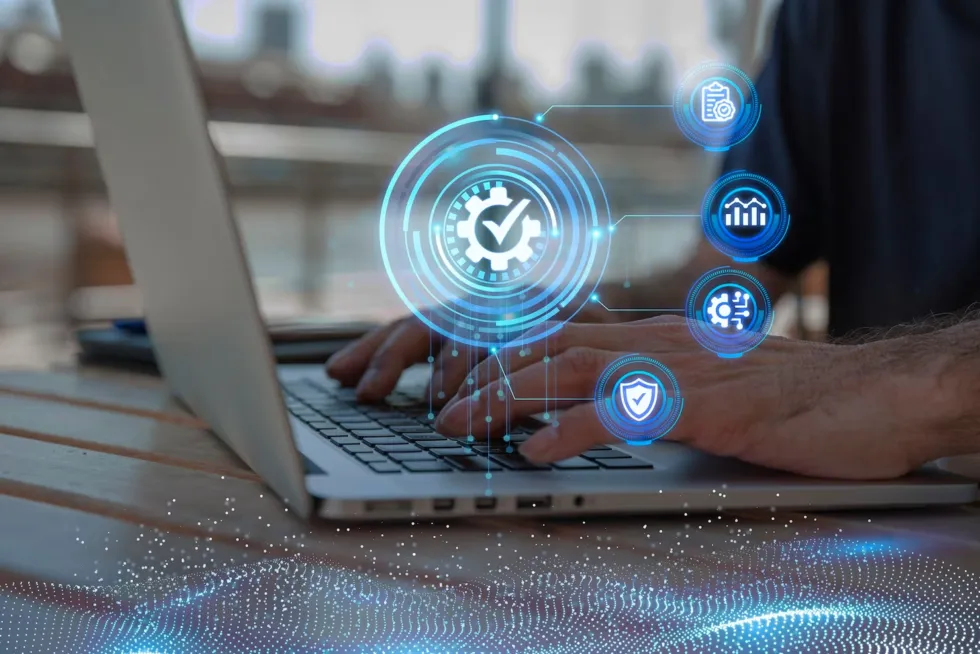 A person typing on a laptop with icons representing managed IT monitoring, reporting, configuration and security overlaid